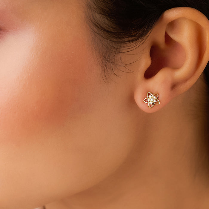 Woman wearing 925 Sterling Silver gold plated flower stud earrings for daily wear. – Zavya