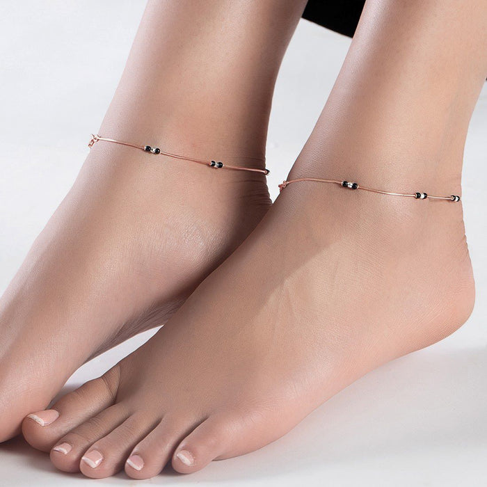 Woman wearing a rose gold-plated 925 Sterling Silver anklet with black beads. Fine jewellery for women – Zavya