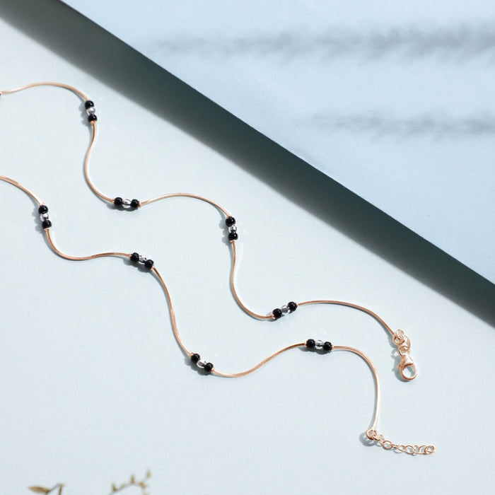 Rose gold-plated 925 Sterling Silver anklet for women featuring a delicate chain and black beads. – Zavya