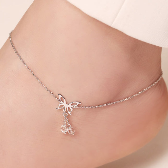 Woman wearing a 925 Sterling Silver butterfly anklet with dangling crystals. Elegant women's jewellery – Zavya