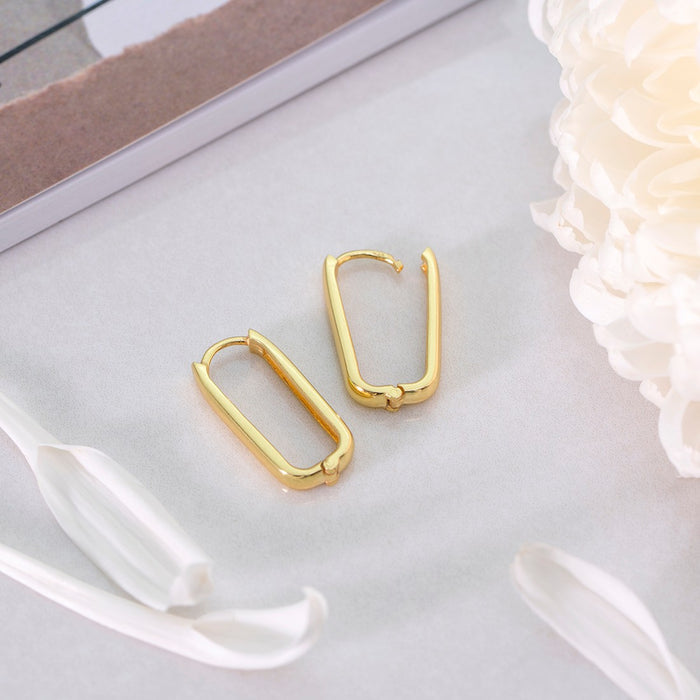 Gold plated 925 sterling silver geometrical hoop earrings for women placed among white petals. – Zavya