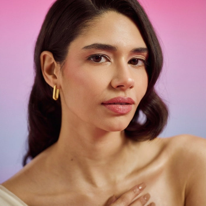 Woman wearing gold plated geometrical hoop earrings in 925 Sterling Silver. Trendy women's jewellery – Zavya