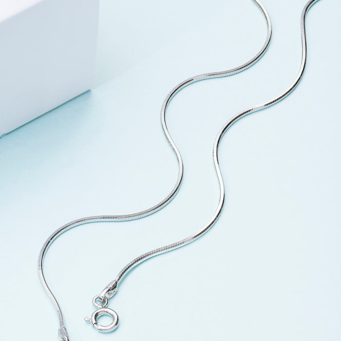 Classic 925 Sterling Silver rope chain anklet for women. Wavy silver jewellery on a pale blue surface. – Zavya