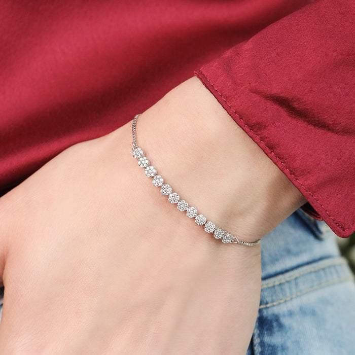 Woman wearing a sparkling floral 925 Sterling Silver bracelet on her wrist. Elegant women's jewellery – Zavya