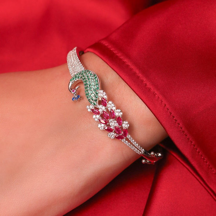 925 Sterling Silver peacock bracelet with red and green stones on a woman's wrist. Fine jewellery for women – Zavya