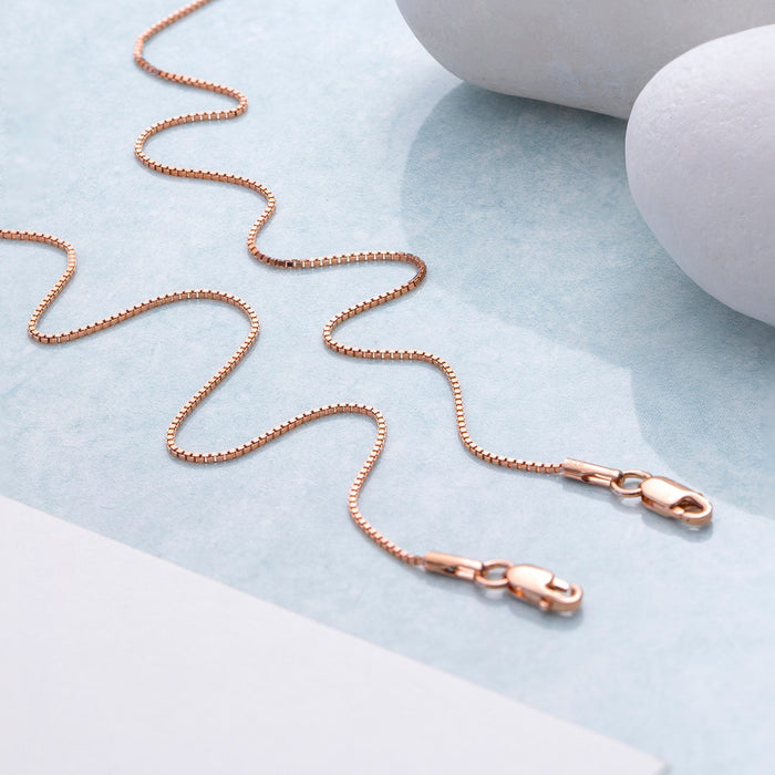 Rose gold 925 Sterling Silver box chain anklet for women placed in waves near white pebbles – Zavya