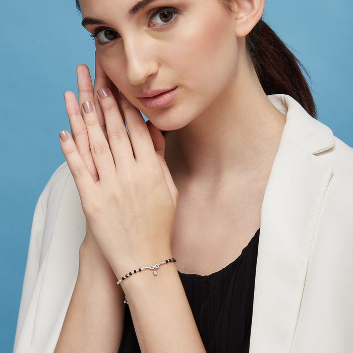 Woman wearing a 925 Sterling Silver infinity mangalsutra bracelet with solitaire drop. Women's jewellery – Zavya