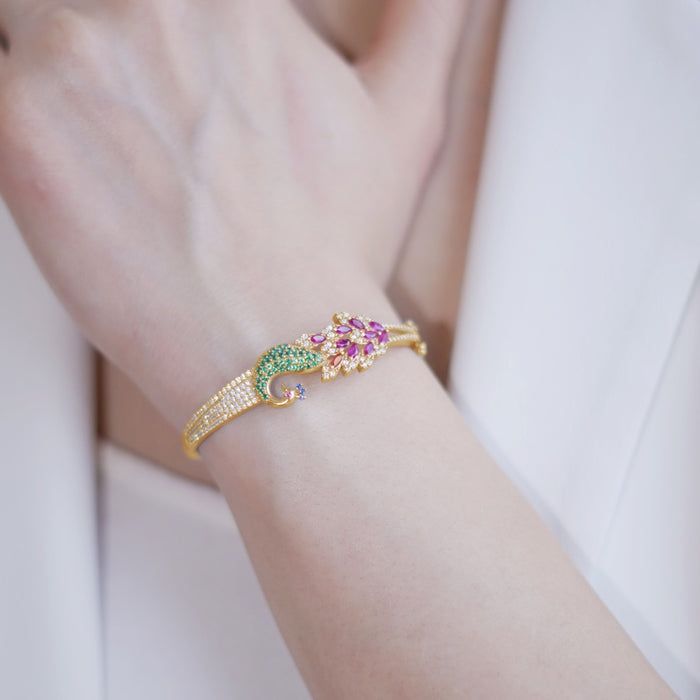 Gold 925 Sterling Silver peacock bracelet for women featuring green and pink stones on a wrist – Zavya