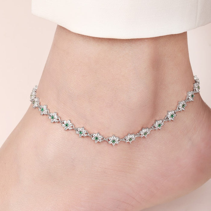 Floral green CZ 925 Sterling Silver anklet worn on a woman's ankle. Fine silver jewellery for women – Zavya