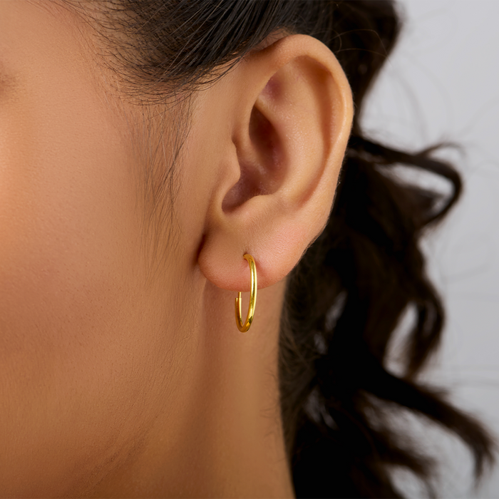 Woman wearing round gold plated 925 Sterling Silver hoop earrings. Everyday women's jewellery – Zavya