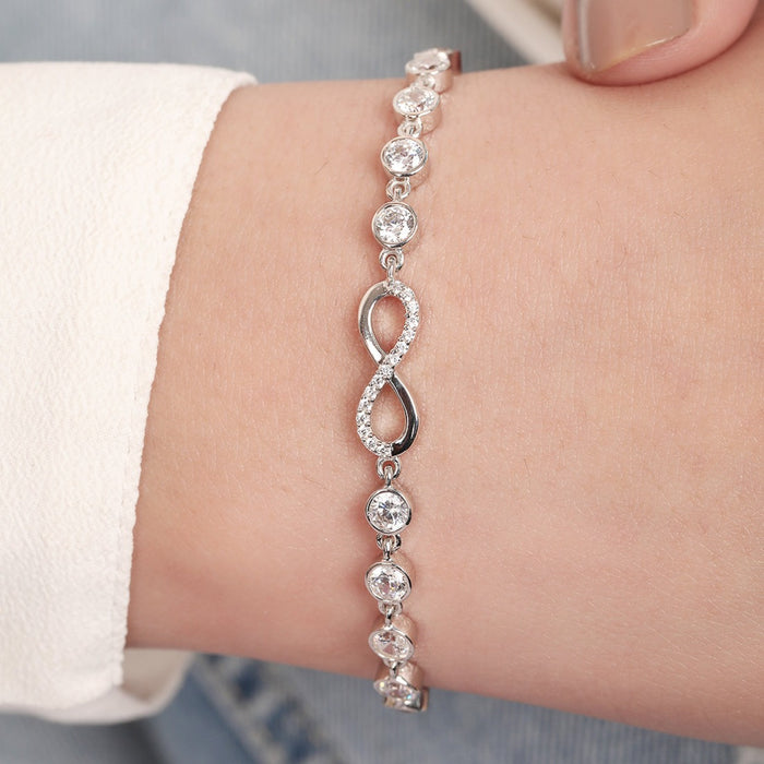 Woman wearing a 925 Sterling Silver bracelet with a sparkling infinity symbol and round stones. – Zavya