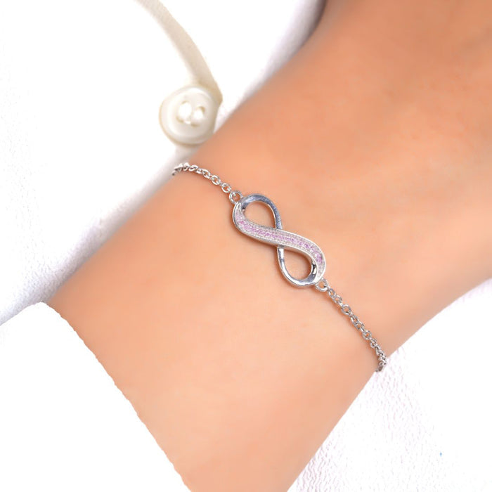 Woman wearing a 925 Sterling Silver infinity charm bracelet with pink stones. Silver jewellery for women – Zavya