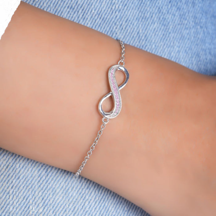 Woman wearing a 925 Sterling Silver infinity bracelet with pink stones. Fine women's jewellery – Zavya