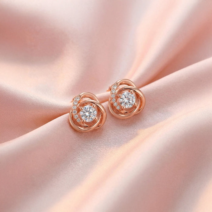Rose gold 925 Sterling Silver knot stud earrings for women with sparkling center stones on pink silk. – Zavya