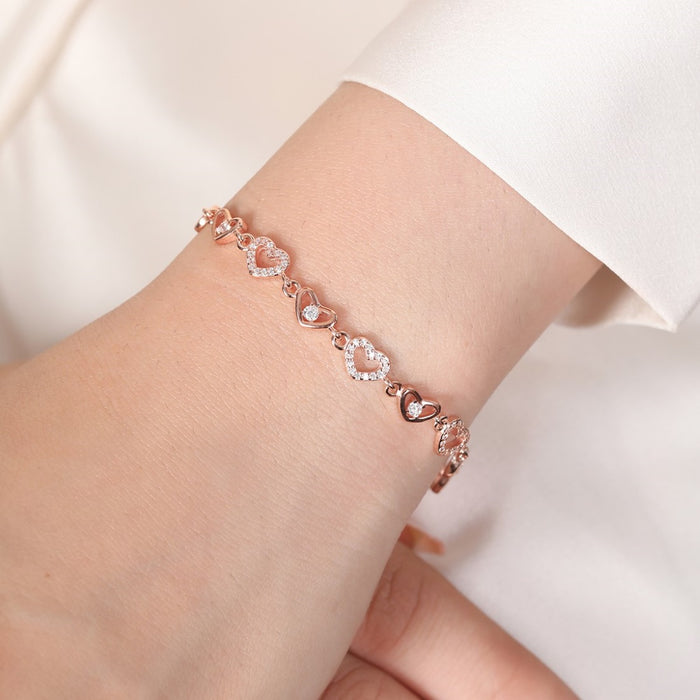 Woman wearing a rose gold 925 Sterling Silver heart bracelet with stones. Elegant jewellery for women – Zavya