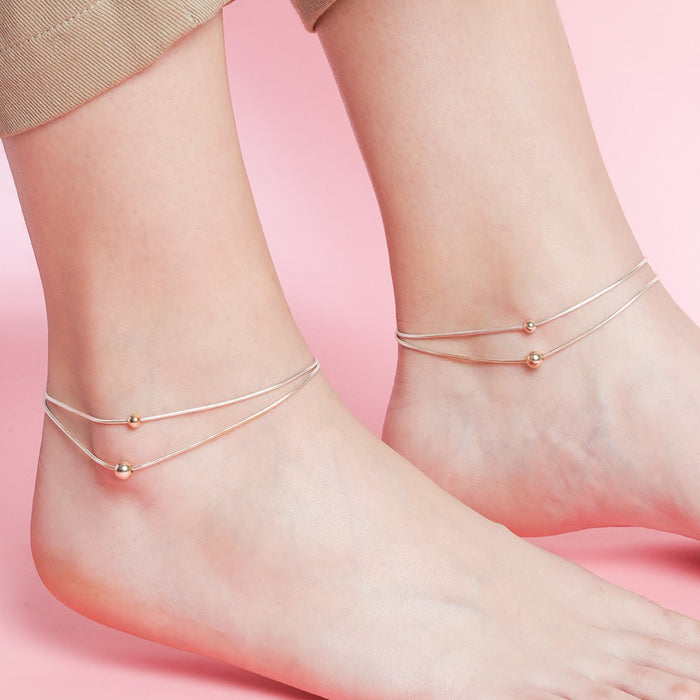 Woman wearing dainty double-layered 925 Sterling Silver bead chain anklets. Everyday jewellery for women – Zavya