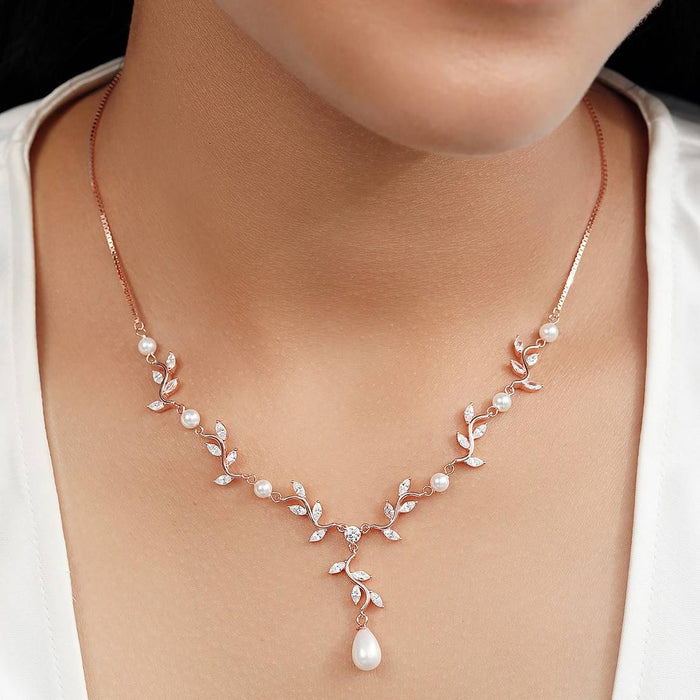 Woman wearing a rose gold plated 925 Sterling Silver leaf drop necklace with pearls. Women's jewelry – Zavya
