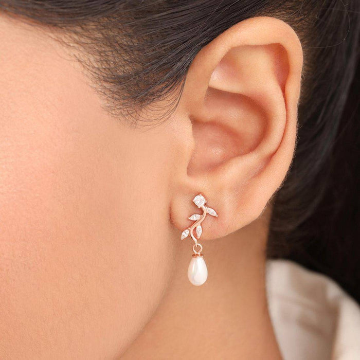 Woman wearing rose gold leaf pearl drop earrings. 925 Sterling Silver jewelry for women. – Zavya