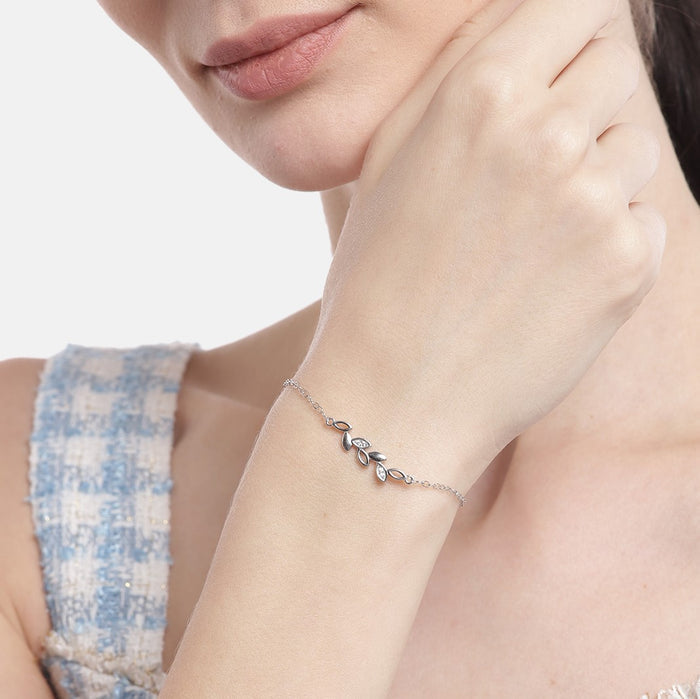 Woman wearing a delicate leaf 925 Sterling Silver bracelet with cubic zirconia. Silver jewelry for women – Zavya