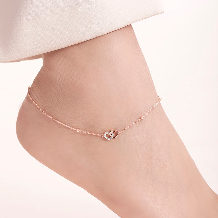 Woman wearing a rose gold plated 925 Sterling Silver linked hearts anklet. Women's jewelry – Zavya