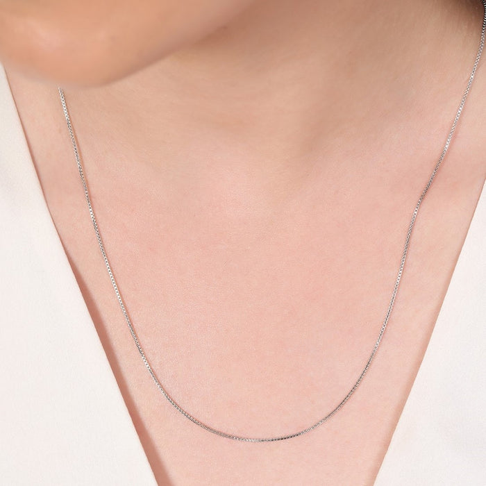Woman wearing a thin 925 Sterling Silver box chain necklace. Minimalist everyday jewelry for women – Zavya