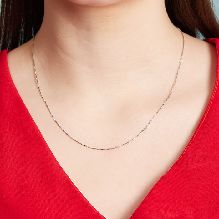 Woman in red wearing a delicate 925 Sterling Silver box chain necklace. Minimal jewellery for women – Zavya