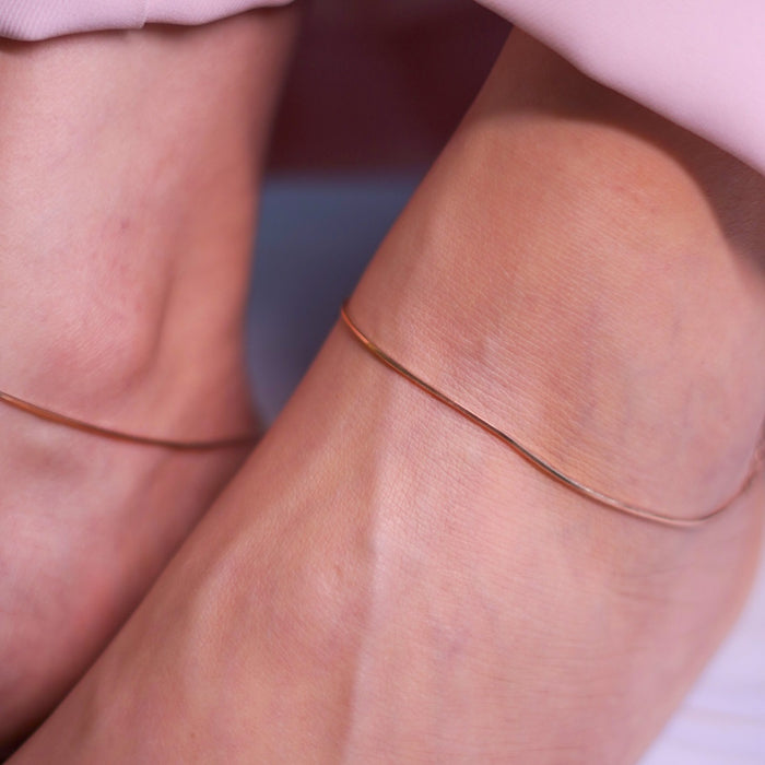 Woman wearing a golden 925 Sterling Silver snake chain anklet. Minimalist anklets for women – Zavya