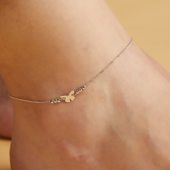 Woman's ankle wearing a delicate butterfly 925 Sterling Silver anklet. Minimalist everyday jewellery – Zavya