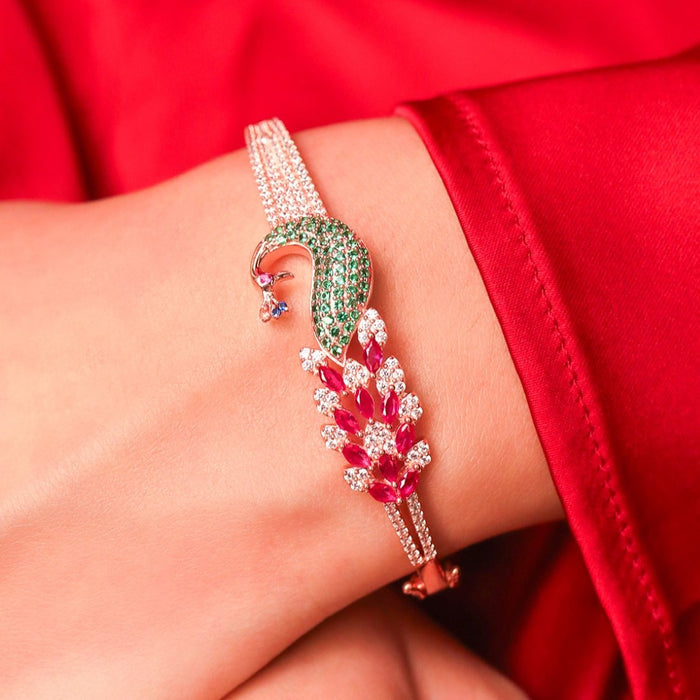 Close-up on wrist: Women's 925 Sterling Silver rose gold peacock bracelet with green & red crystals – Zavya