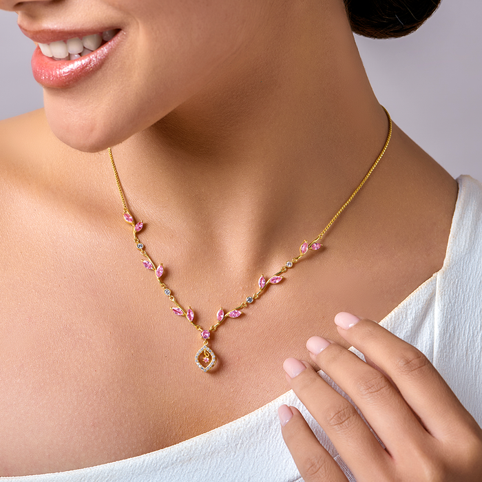Smiling woman in a gold-plated 925 Sterling Silver necklace with pink blossom stones. Women's jewellery – Zavya