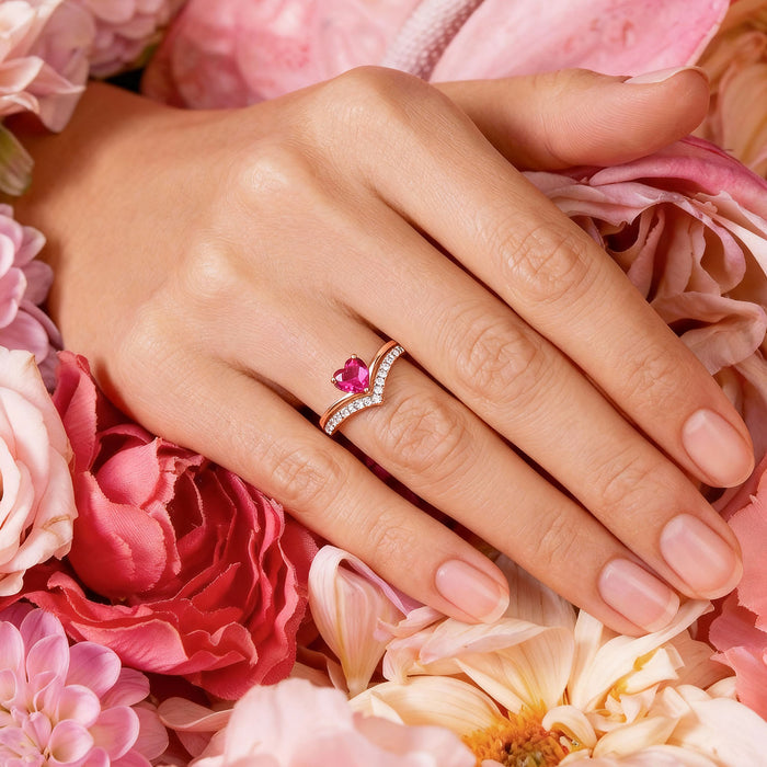 Hand wearing a rose gold 925 Sterling Silver ring with a pink heart and crystal band on pink flowers – Zavya