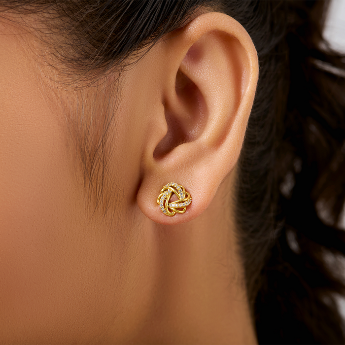Woman wearing gold plated 925 Sterling Silver knot stud earrings. Everyday jewellery for women – Zavya