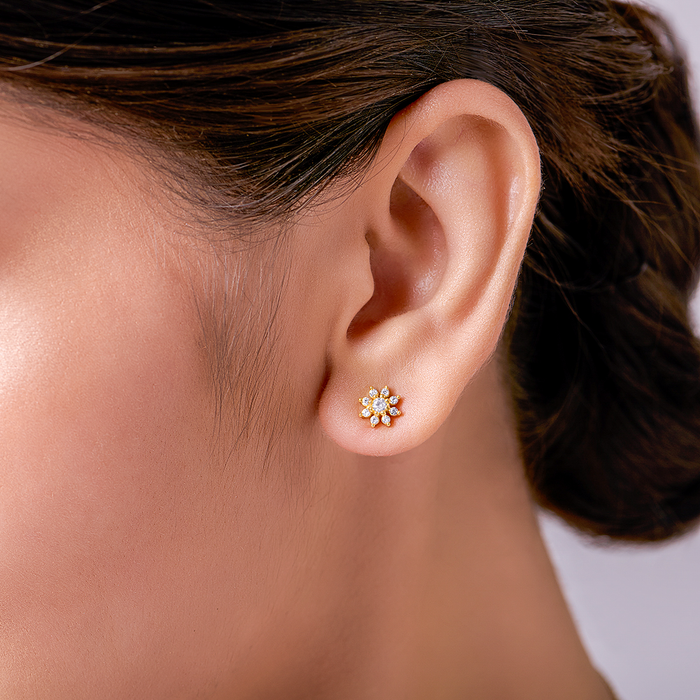 Woman wearing gold floral 925 Sterling Silver stud earrings with cubic zirconia, women's jewellery – Zavya