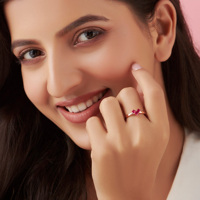 Smiling woman wearing a rose-gold plated ruby heart 925 Sterling Silver ring. Elegant jewellery for women – Zavya