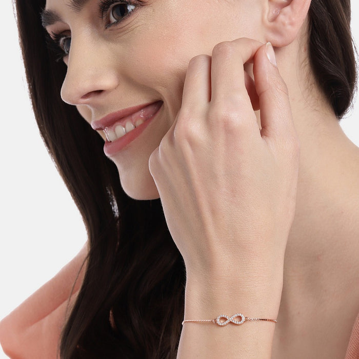 Smiling woman wearing a minimal rose gold infinity 925 Sterling Silver bracelet. Women's jewellery – Zavya
