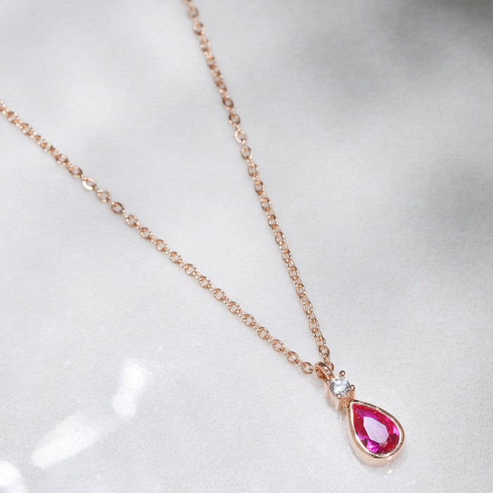 Women's rose gold plated 925 Sterling Silver necklace with a ruby teardrop pendant on white marble – Zavya