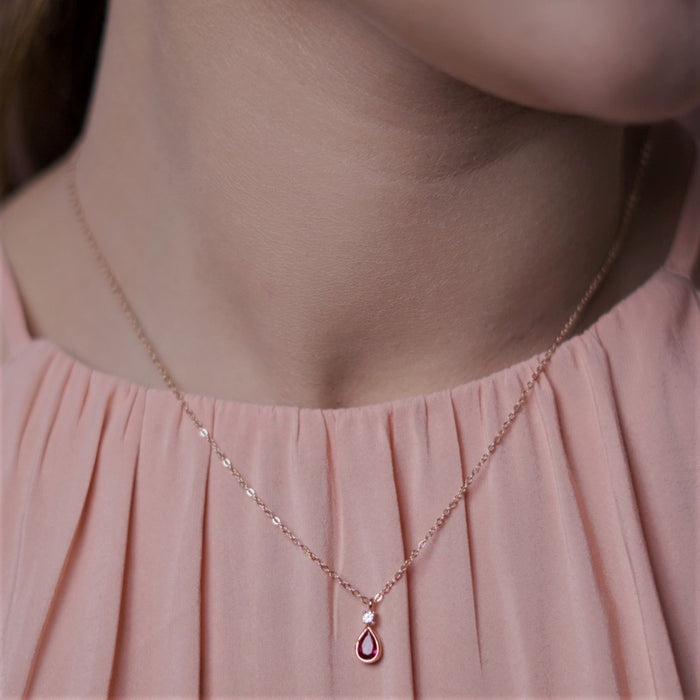 Woman wearing a rose gold plated 925 Sterling Silver necklace with ruby tear drop pendant. Women's jewellery – Zavya