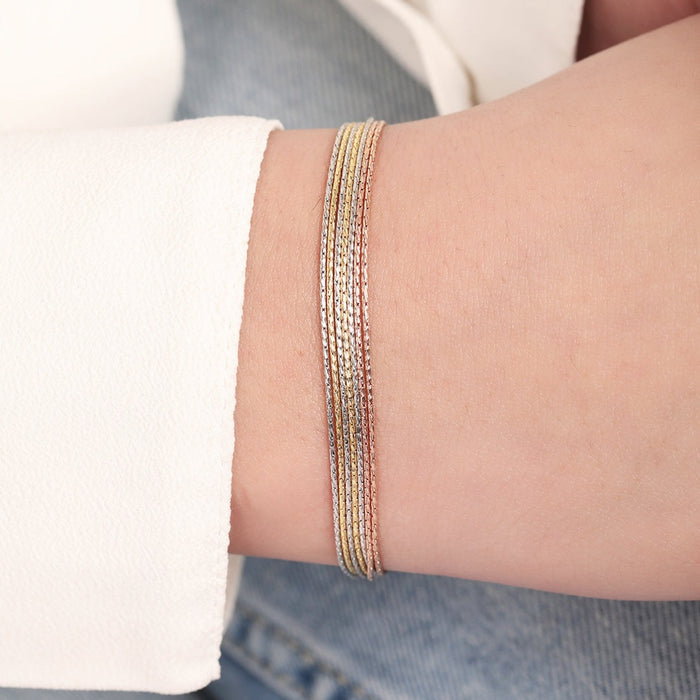 Woman wearing a layered triple tone 7-chain 925 Sterling Silver bracelet. Women's jewellery – Zavya