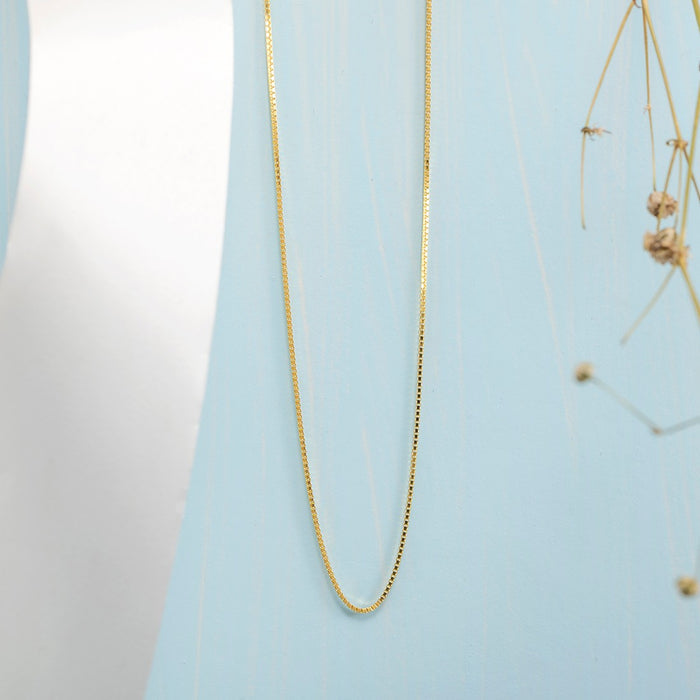Sleek gold plated 925 Sterling Silver box chain necklace for women on a light blue background – Zavya