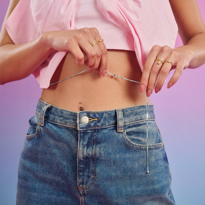 Woman adjusting a 925 Sterling Silver sliding waist chain on her bare belly above jeans – Zavya