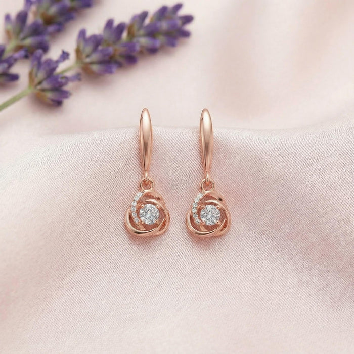 925 Sterling Silver rose gold drop earrings for women with a sparkling orbit design on pink fabric. – Zavya