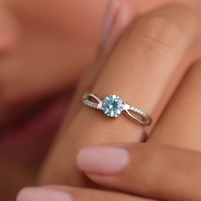 Close-up of woman wearing a sparkling blue CZ 925 Sterling Silver ring. Silver jewelry for women – Zavya