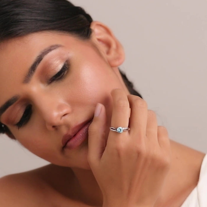 Woman touching her face wearing a blue CZ 925 Sterling Silver adjustable ring. Silver rings for women – Zavya