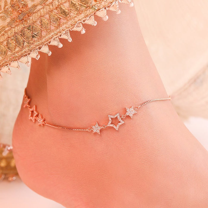 Woman wearing a rose gold plated 925 Sterling Silver anklet with cubic zirconia star charms. Women's jewelry – Zavya