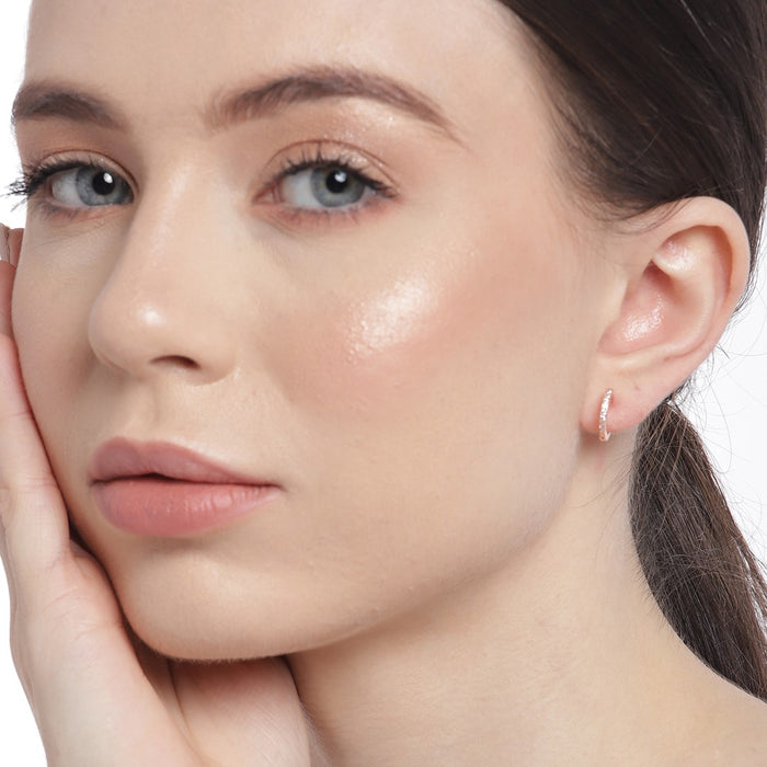 Woman wearing a dainty 925 Sterling Silver rose gold hoop earring. Everyday fine jewellery for women. – Zavya