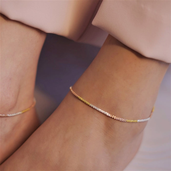 Woman wearing a dainty triple tone weave chain 925 Sterling Silver anklet. Women's jewellery – Zavya
